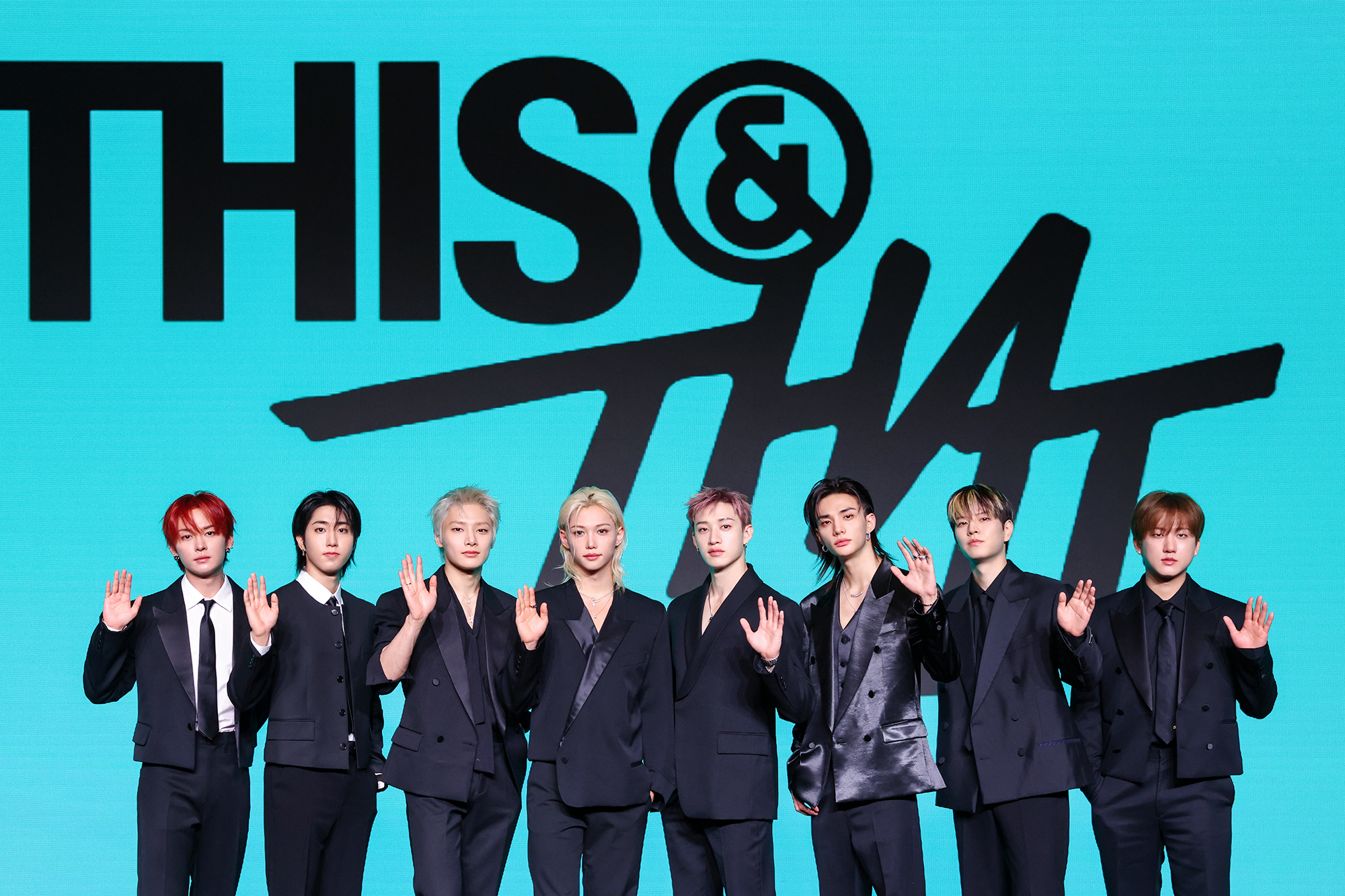 「THIS & THAT」のロゴを背に並ぶStray Kidsのメンバー8人