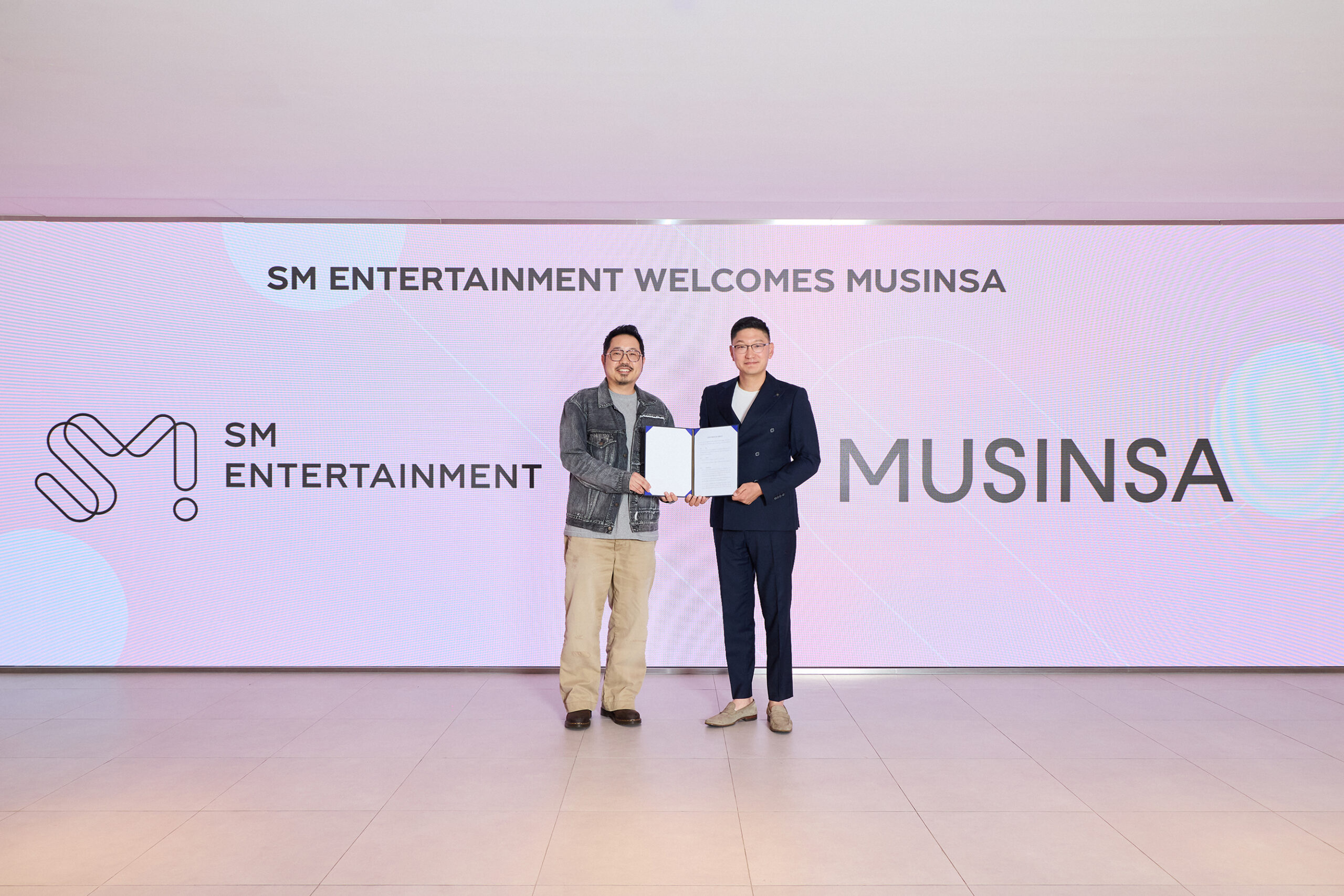 タク・ヨンジュンSM共同代表(右)とチェ・ジェヨンMUSINSA CCO(左)が14日、ソウル城水洞のSM本社で業務協約式を終えたあと記念撮影する様子